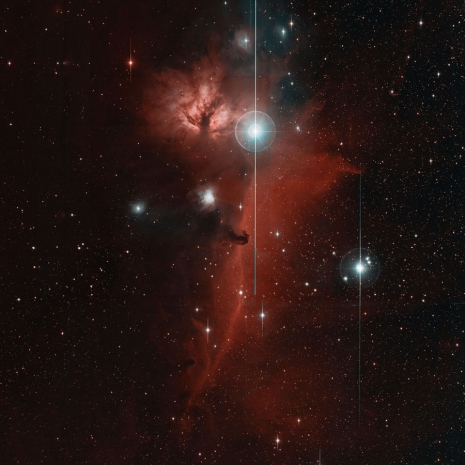 The Horsehead nebula can be seen in this portion of the "first-light" image from ZTF. The head of the horse (middle) faces up toward another well-known nebula known as the Flame. Violet to green wavelengths detected by ZTF are represented as cyan, while yellow to deep red wavelengths are shown as red. Computers searching these images for transient, or variable, events are trained to automatically recognize and ignore non-astronomical sources, such as the vertical "blooming" lines seen here. Image credit: Caltech Optical Observatories