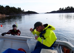 Johan Eklöf studerar fångsten i en planktonhåv. Foto: Ulf Bergström