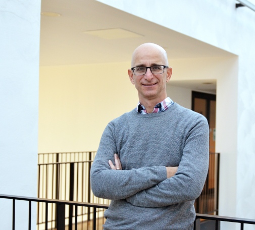 Ariel Goobar with arms crossed standing inside the AlbaNova building.